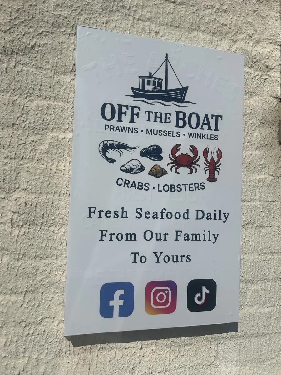 Off The Boat shop sign displaying the fishing boat, seafood and From Our Family To Yours message